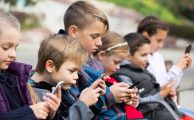 Outdoor portrait of girls and boys playing with phones