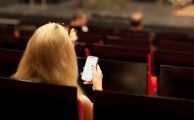 woman with a smartphone in an empty theater