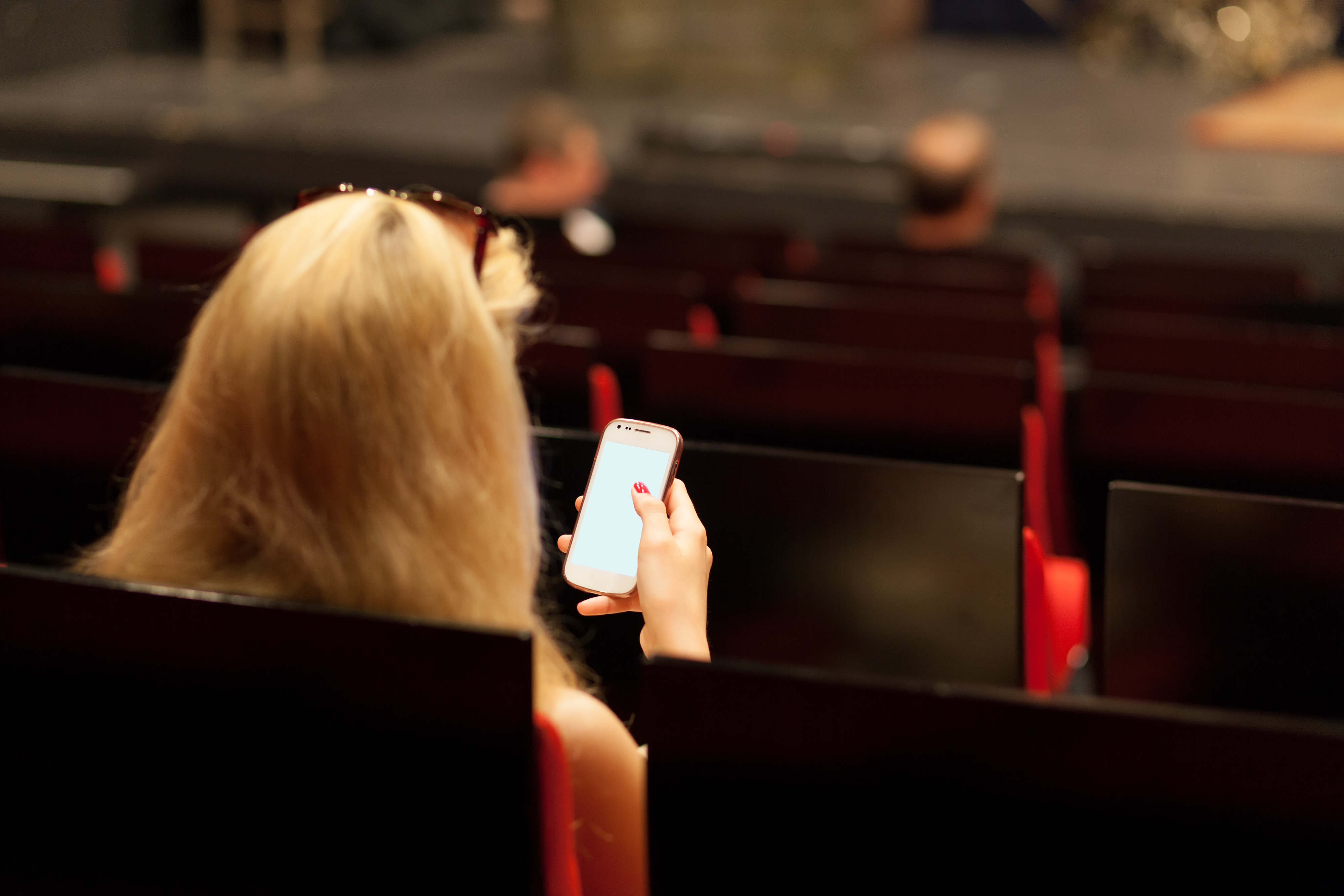 woman with a smartphone in an empty theater