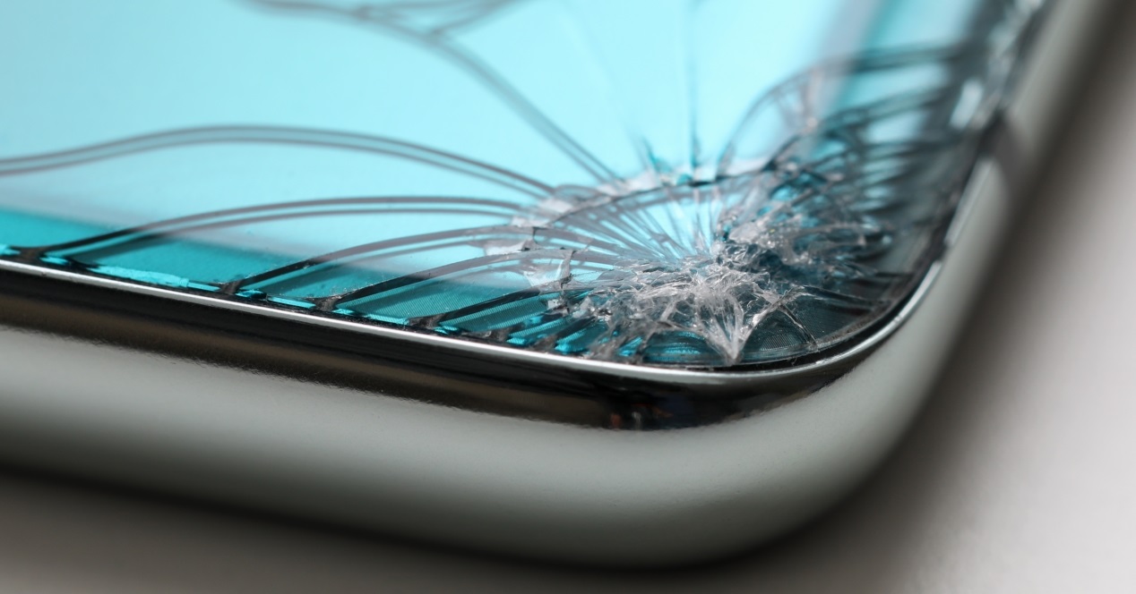 Modern Smartphone Lying At Table With Crack In Corner Close Up
